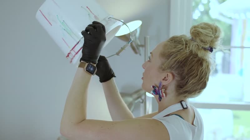 Content film still, artist reviewing an abstract painting