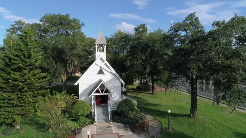 Narrative film still, aerial view of a small white chapel