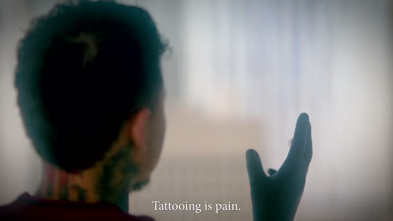 Tattoo studio brand film still, on-screen text reads Tattooing is pain